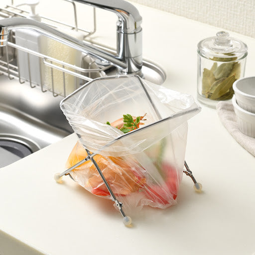 EcoFrame Stainless Compost Holder with a plastic bag set inside, providing a compact, convenient solution for food waste disposal and keeping the kitchen clean.