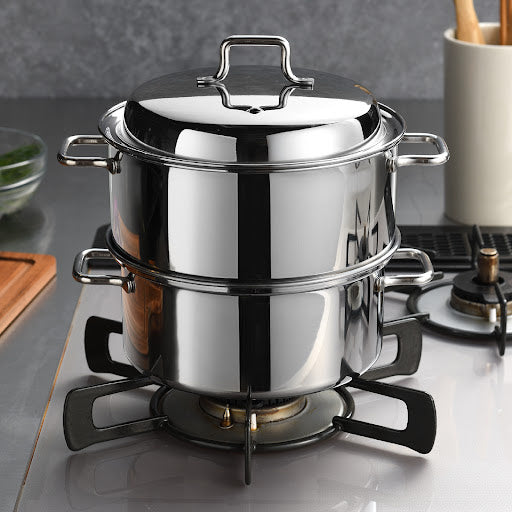 Compact stainless steel steamer placed on a gas stove, ready for use in steaming ingredients for a flavorful meal.