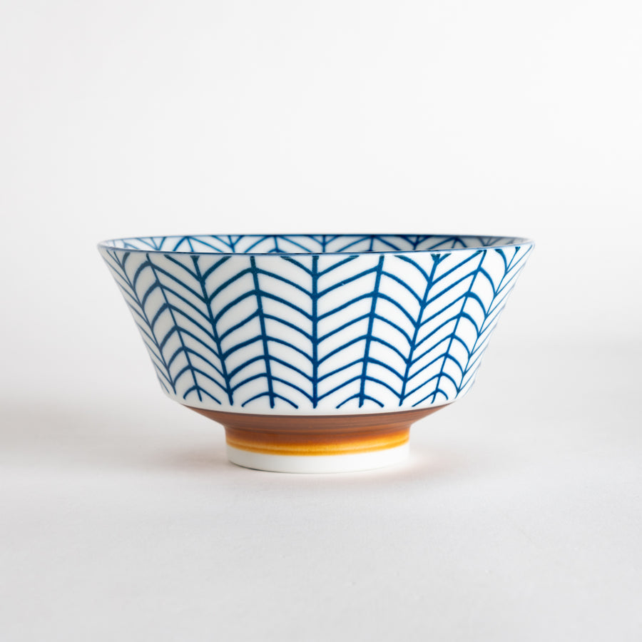 Side view of a bowl featuring an intricate blue arrow feather pattern against a white background, highlighting its elegant shape and design.