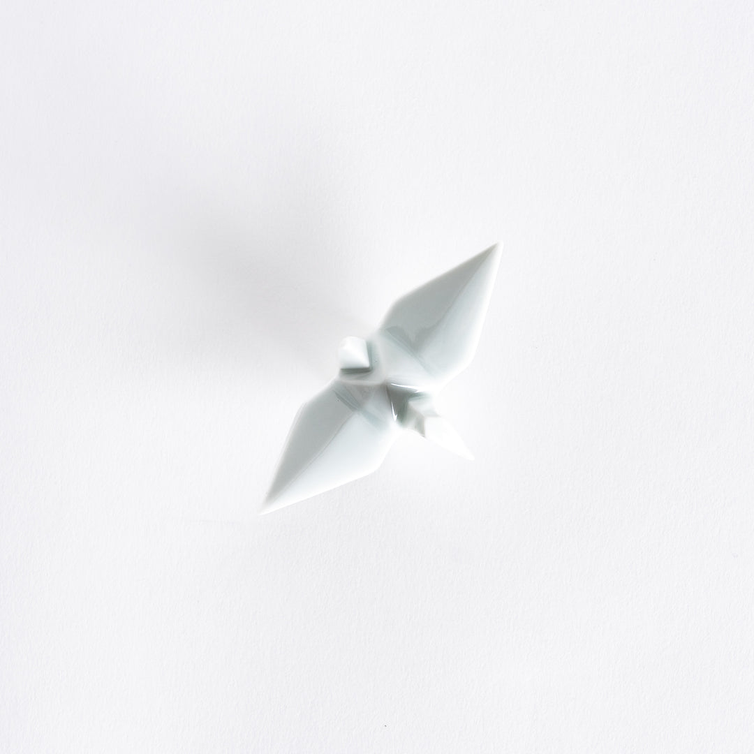 Top view of the white ceramic crane-shaped chopstick rest on a white surface.