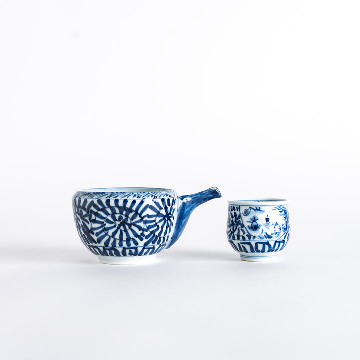 Side view of the sake set, featuring a sake cup and a sake serving vessel with a detailed blue arabesque landscape design.