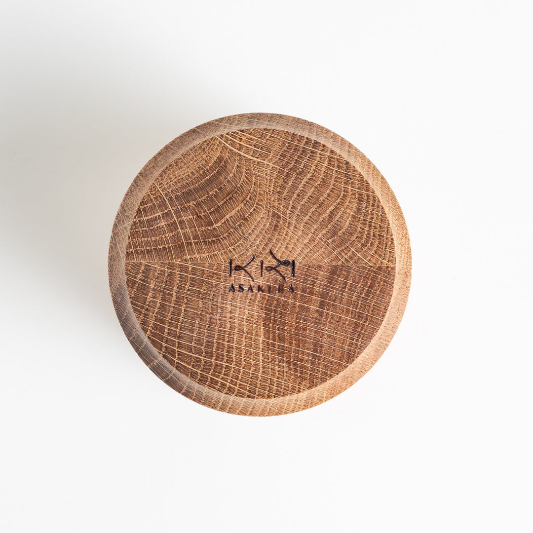 Wooden cup viewed from above, showcasing the smooth finish and natural texture of the Mizunara oak with a brand mark engraved at the top.