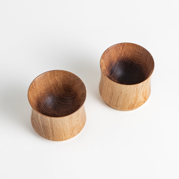 Two Artisan Mizunara Oak whisky cups, showing the smooth interior and natural wooden finish.