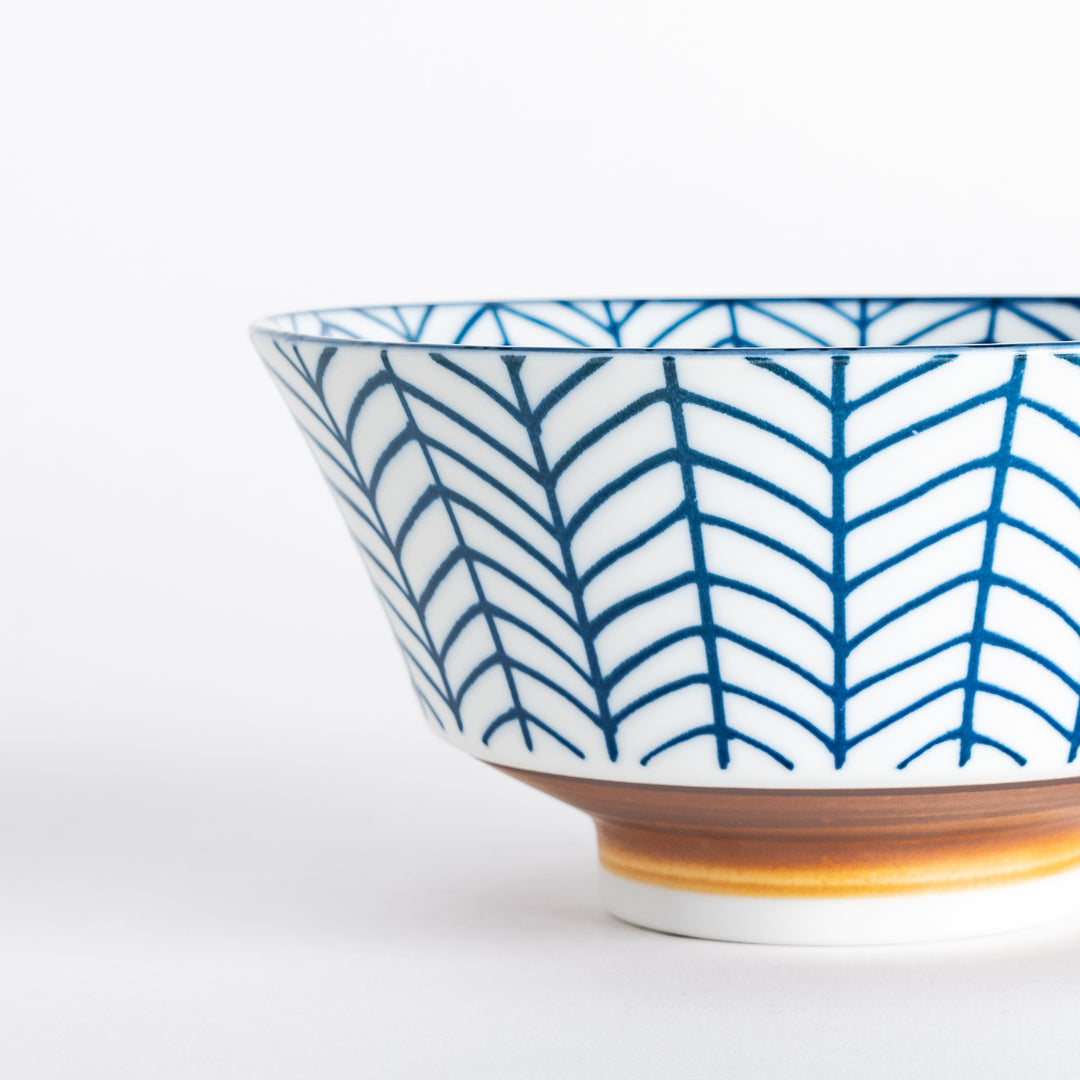 Ceramic ramen bowl with blue striped pattern on white background.