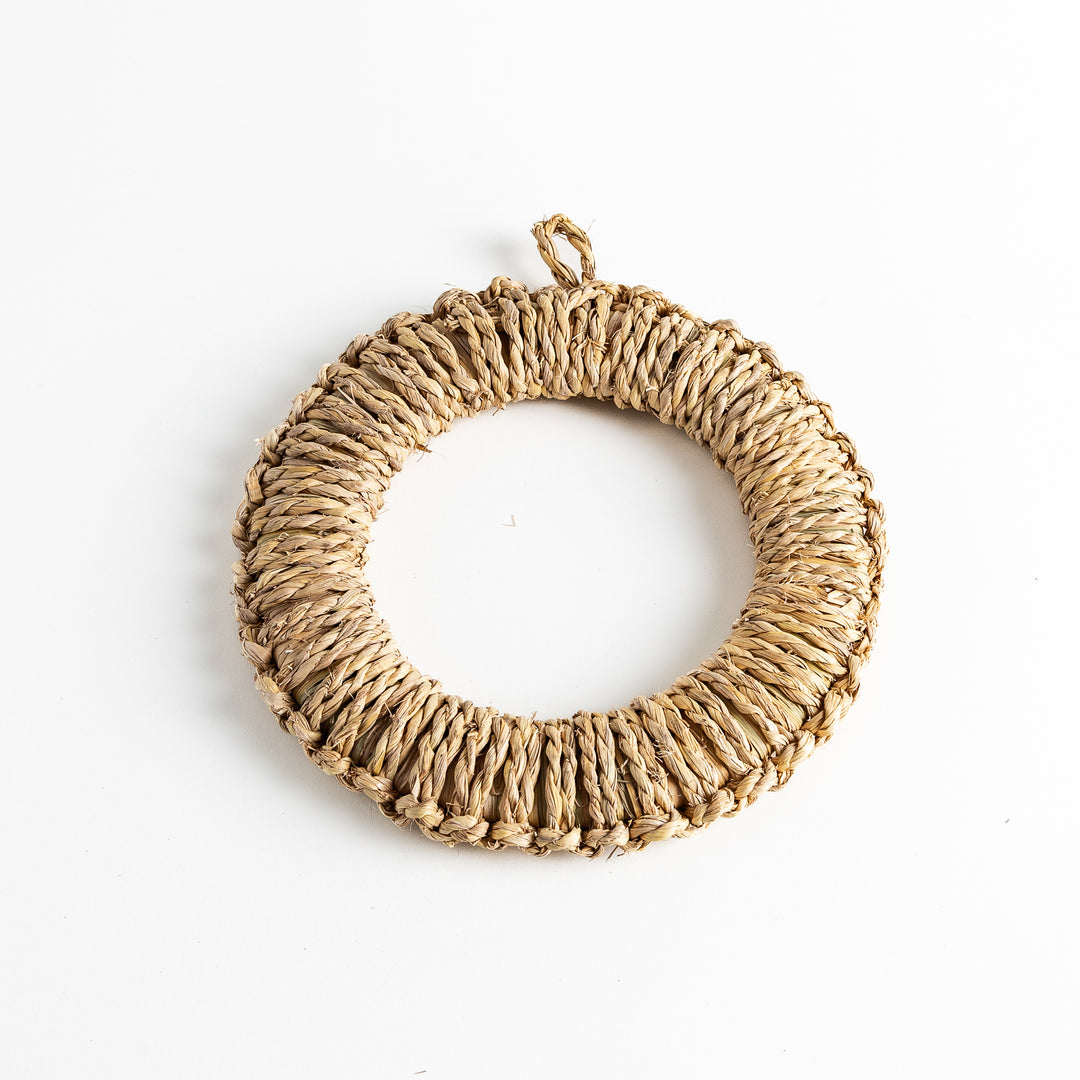 Handwoven rush trivet in large size, crafted with intricate woven texture, featuring a circular shape with a loop for easy hanging.