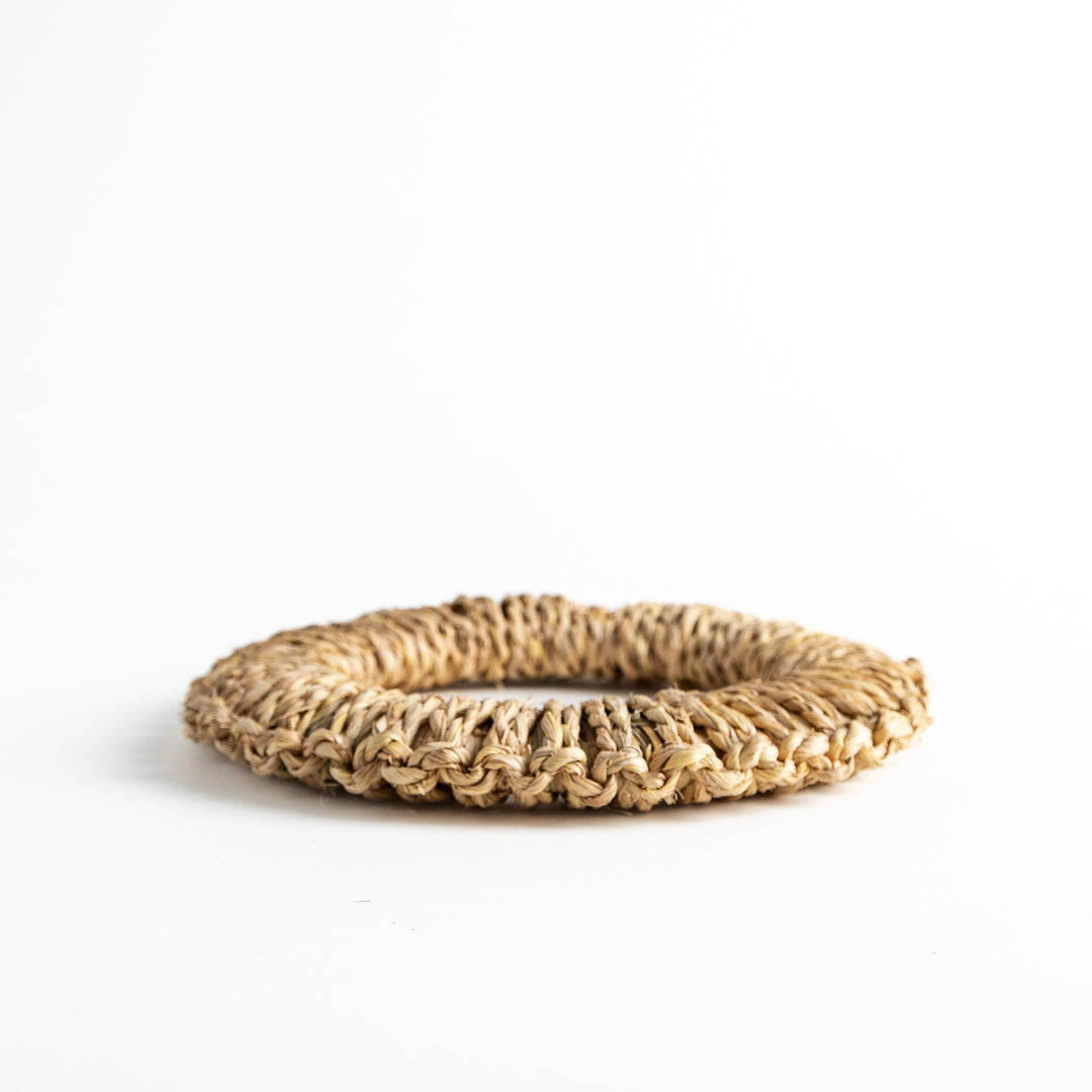 Handwoven rush trivet in large size, with a side view showing the circular shape and the texture of the woven material.