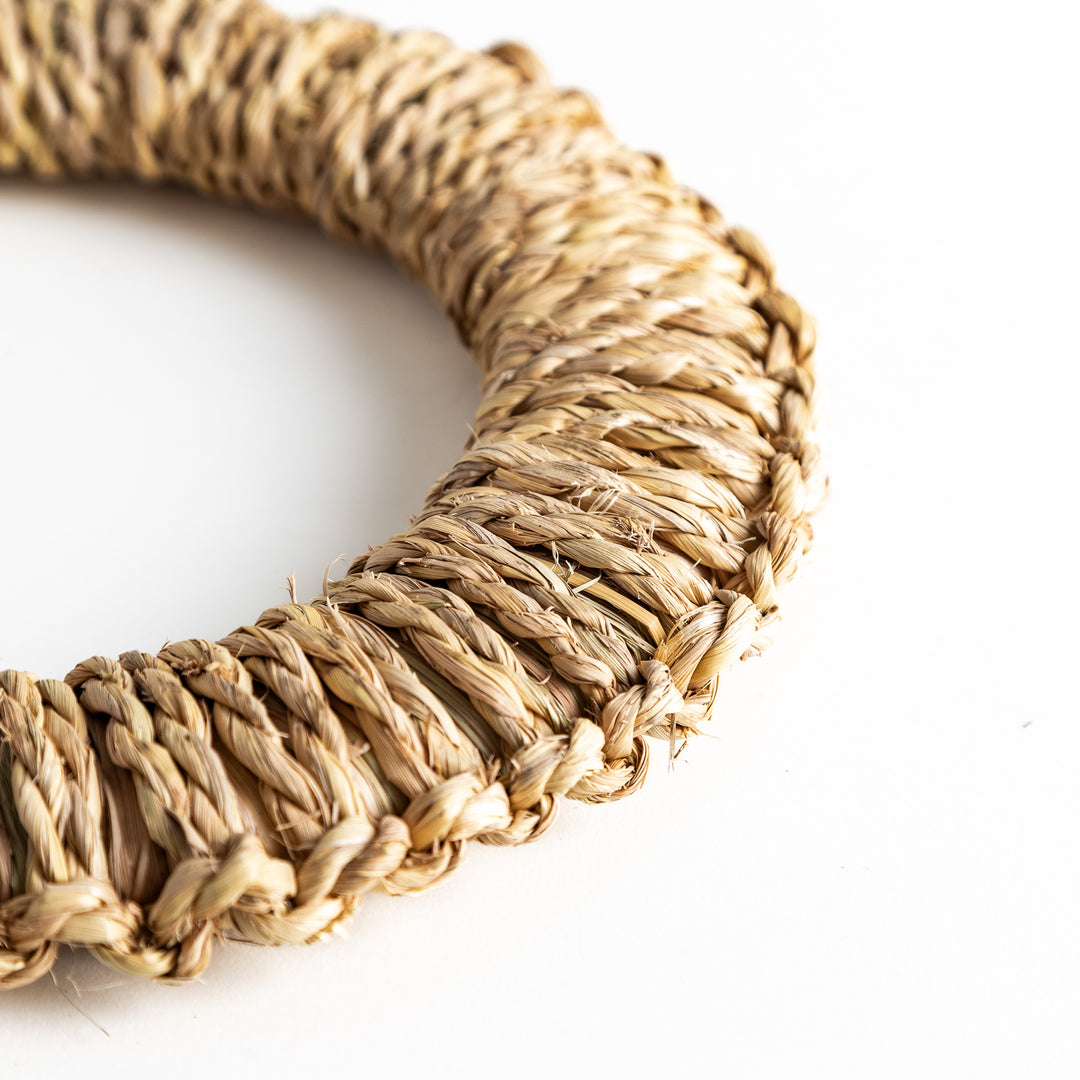 Detailed close-up of the handwoven rush trivet, highlighting the finely woven texture and circular shape.