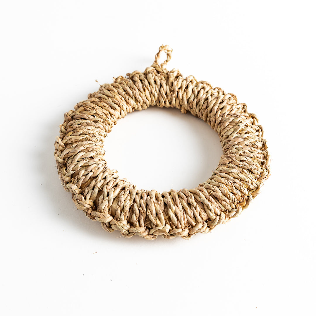 A natural straw trivet with beautiful woven patterns, perfect for placing hot dishes or pots. A simple yet stylish addition to any kitchen.