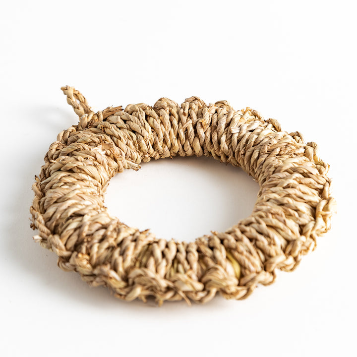 Close-up of a single round rush trivet with intricate, tightly woven detail.