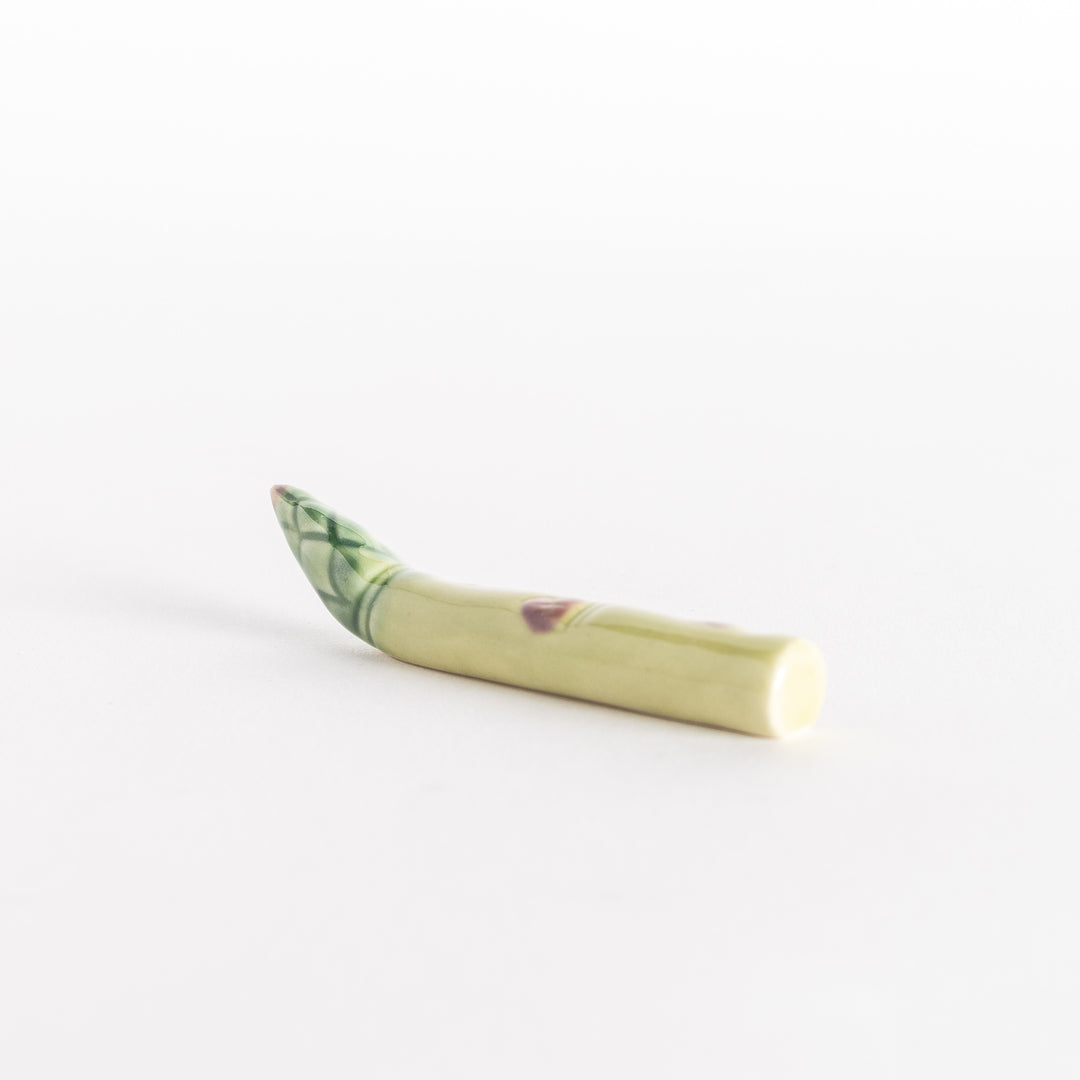 Side view of the ceramic asparagus chopsticks rest, showing its smooth, natural shape.