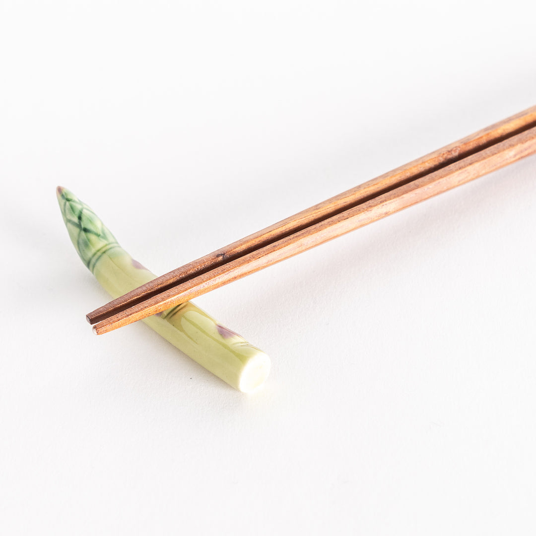 Close-up of the asparagus chopsticks rest with chopsticks placed gently on top.