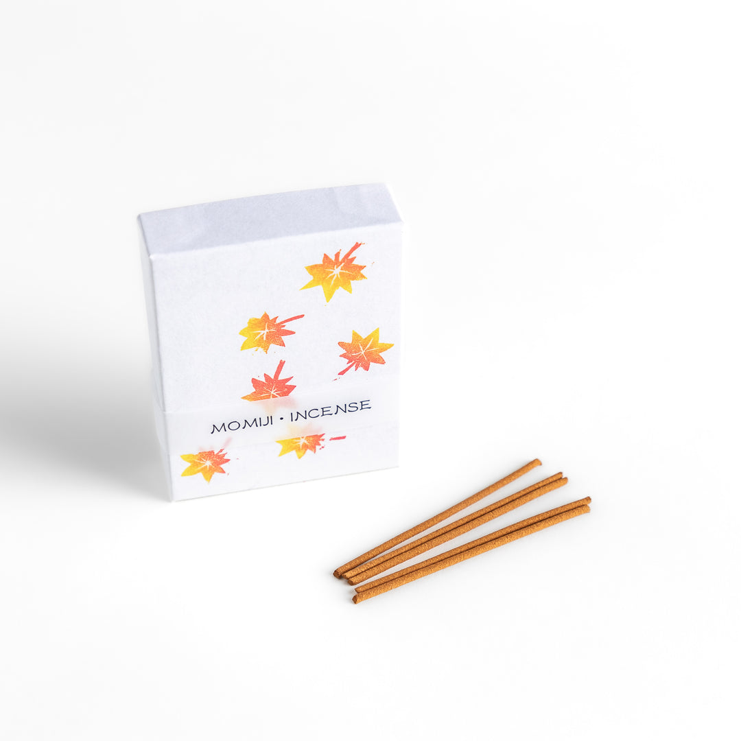 Incense featuring warm-toned sticks in a box decorated with vibrant autumn maple leaves, offering a rich, earthy fragrance inspired by the essence of fall.