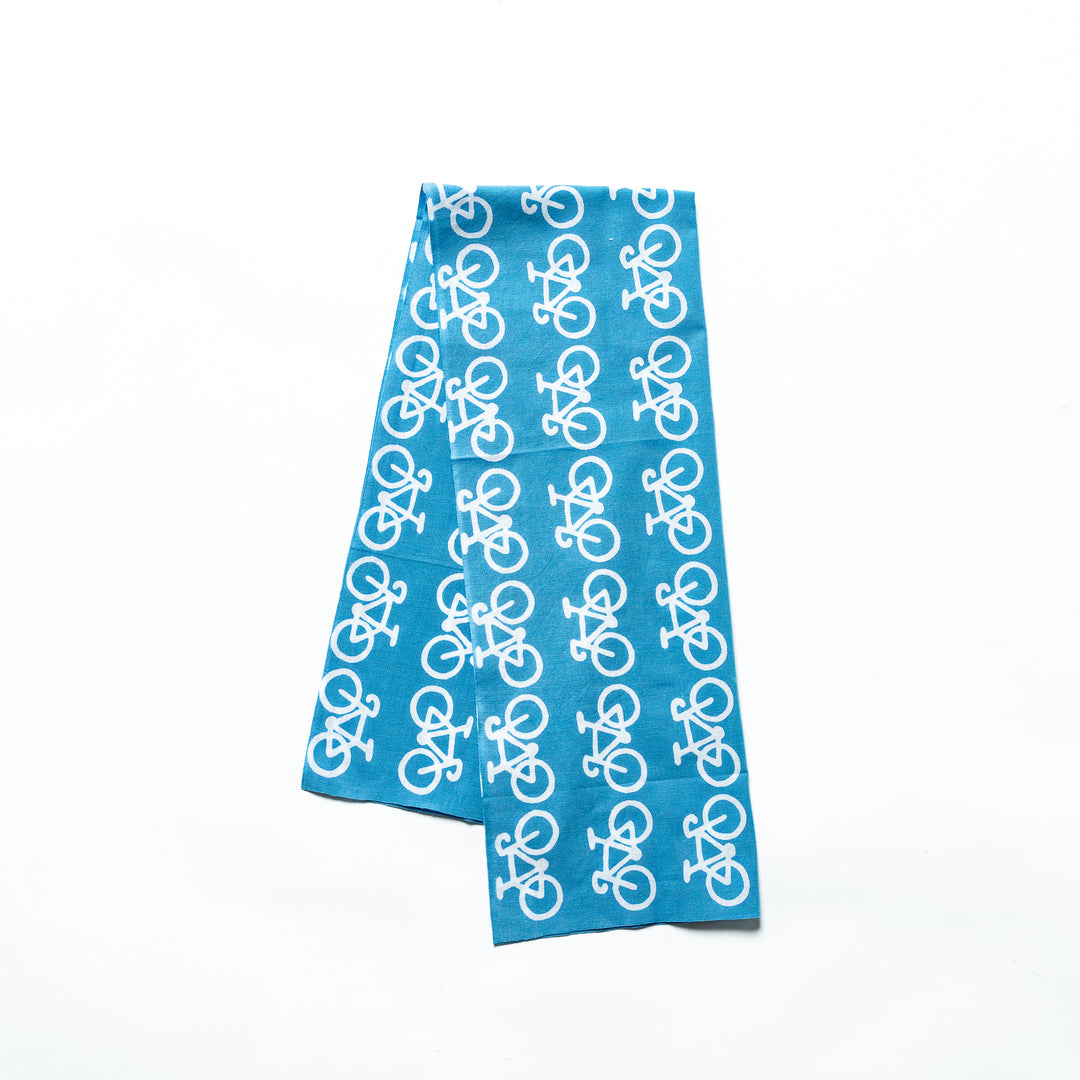 A blue tenugui hand towel featuring a repeated white bicycle pattern.