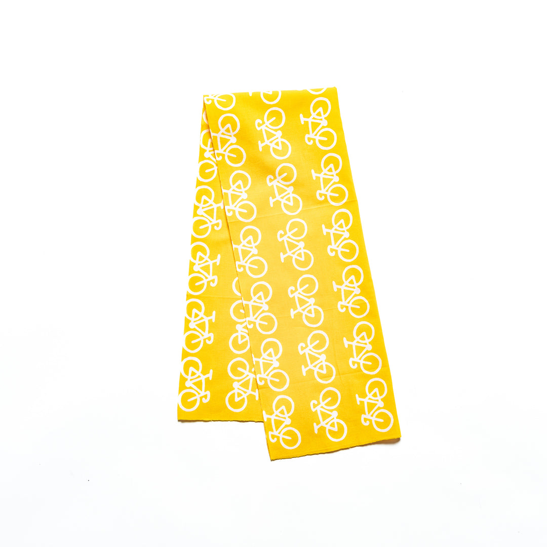 A yellow tenugui hand towel featuring a repeated white bicycle pattern.