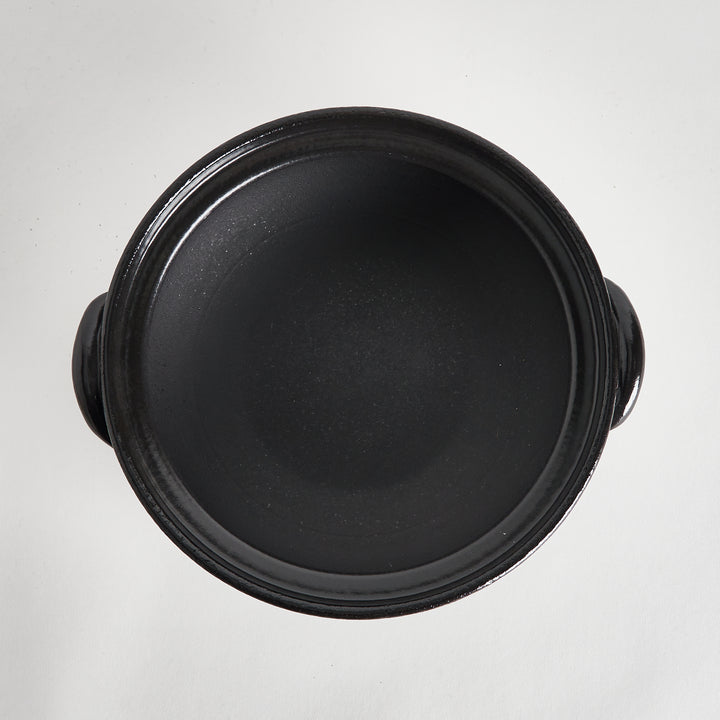 Overhead view of the black interior of the donabe, highlighting its smooth and spacious cooking surface.