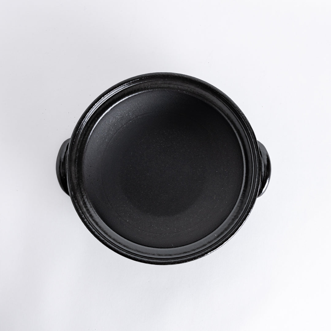 A donabe with a vibrant black floral pattern lid and black pot.