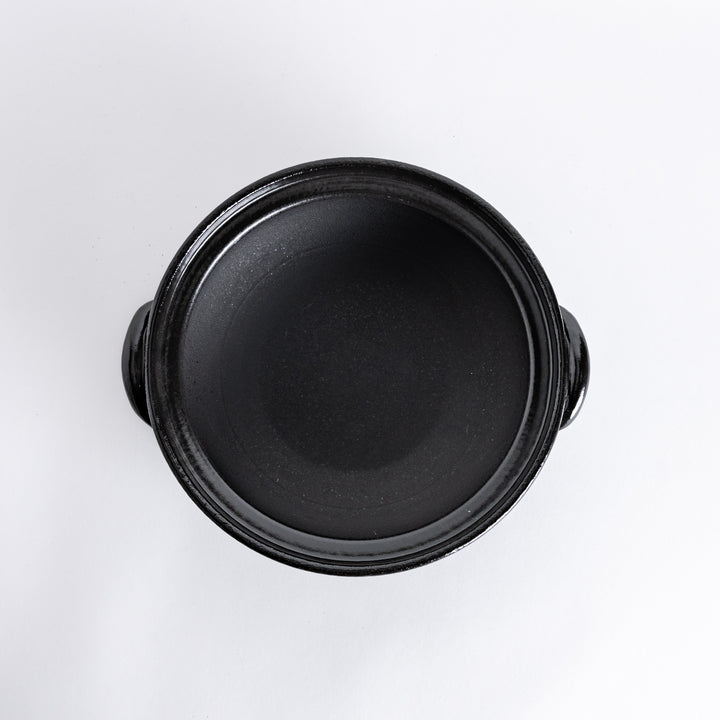 A donabe with a vibrant black floral pattern lid and black pot.