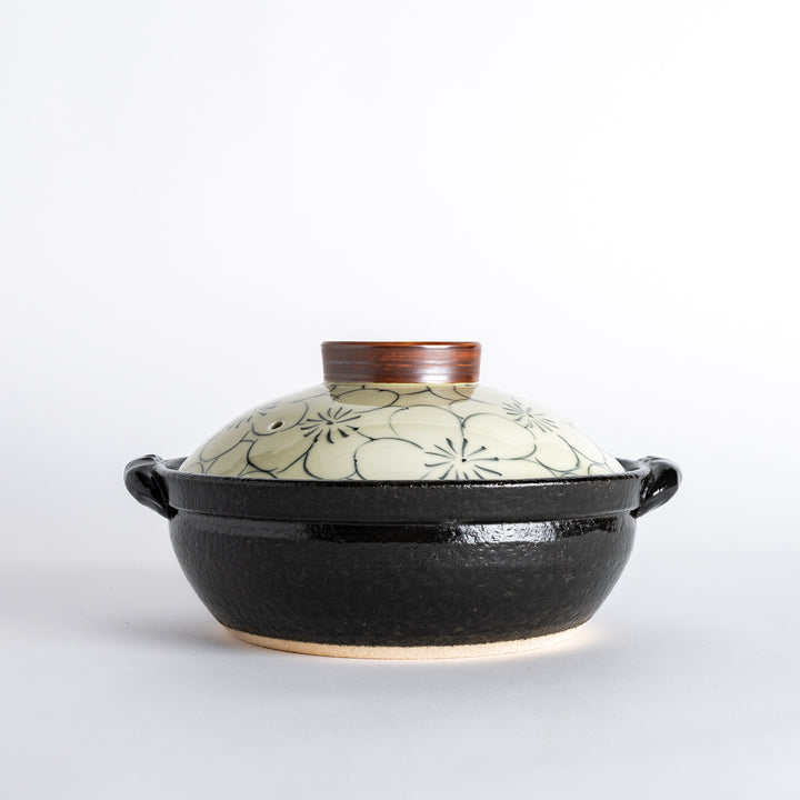 A 8-inch donabe with a vibrant black floral pattern lid and black pot.