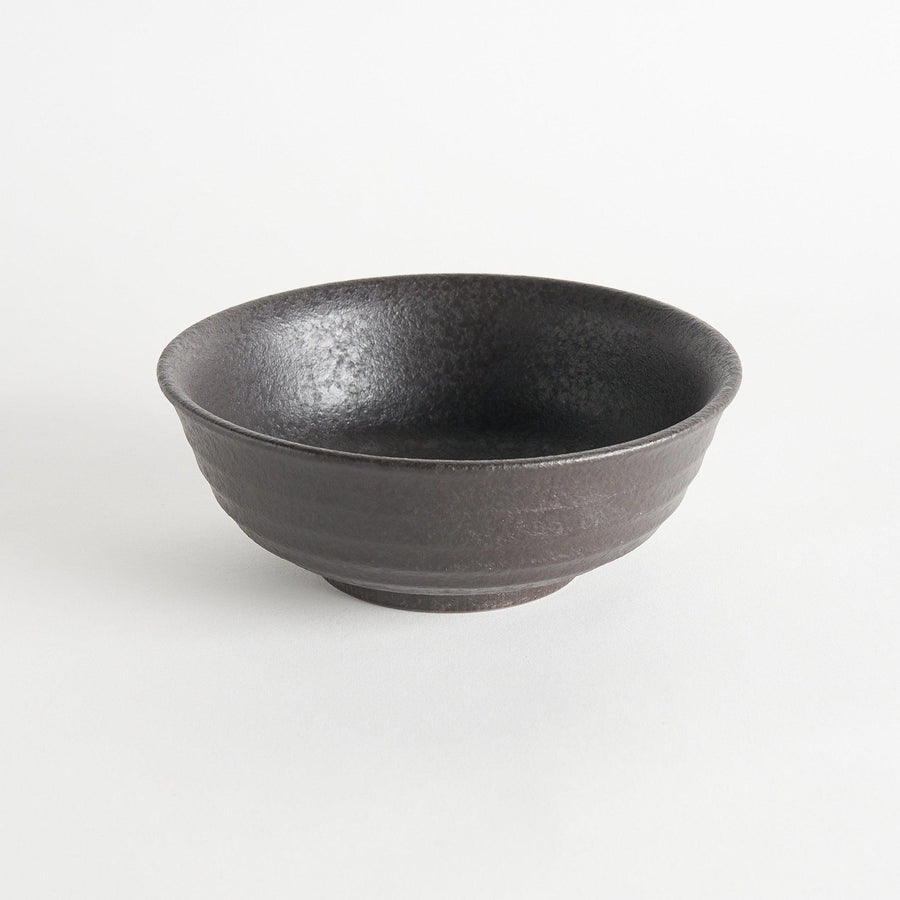 A bowl with a textured, matte black finish, offering a rustic aesthetic.