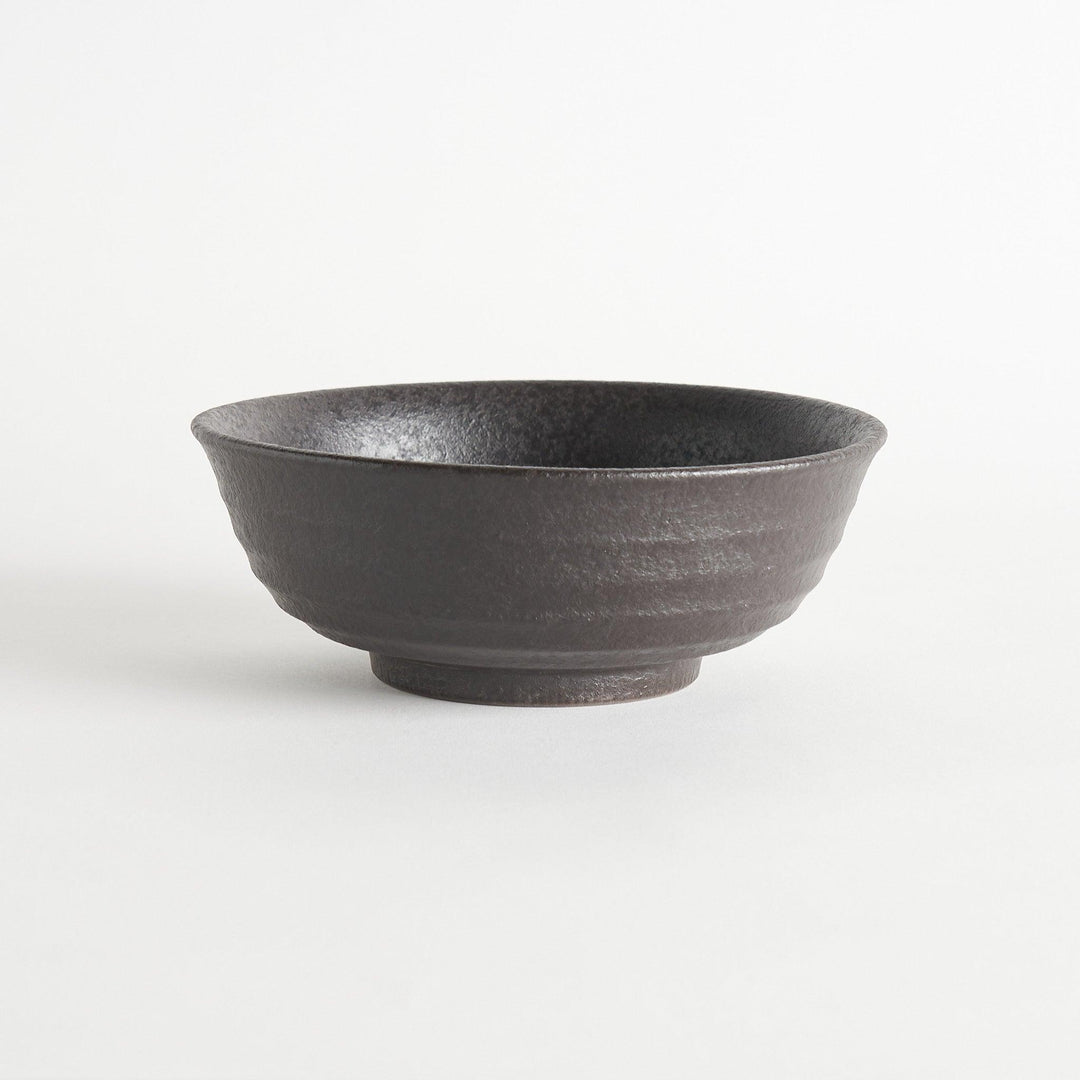 A bowl with a textured, matte black finish, offering a rustic aesthetic.