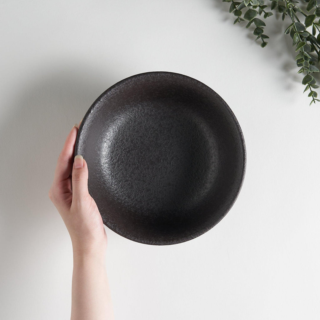 A bowl with a textured, matte black finish, offering a rustic aesthetic.