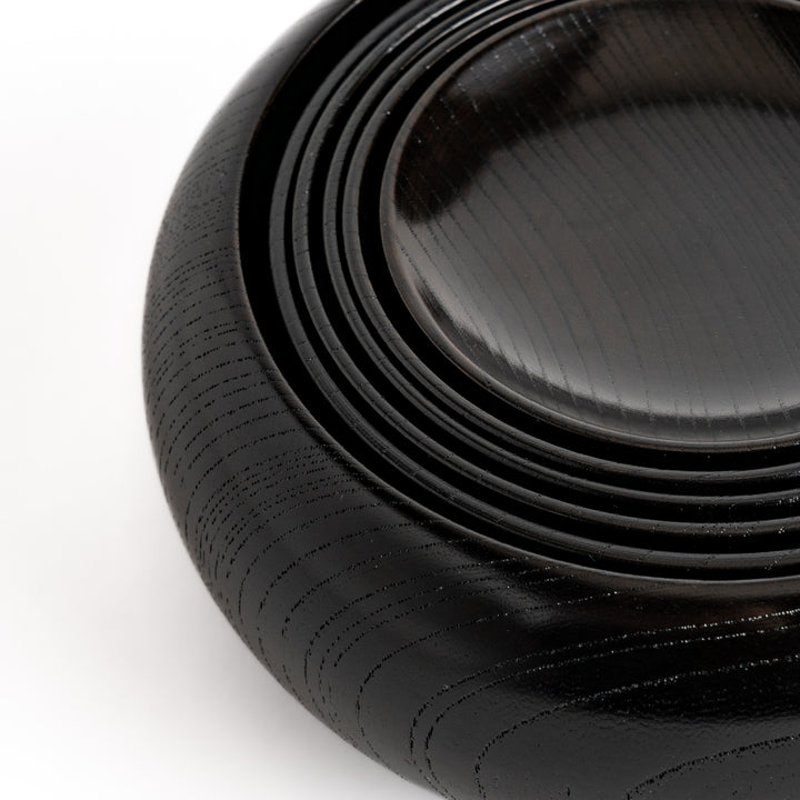 Black lacquered Oryoki bowl set featuring a large serving bowl, three medium bowls, and three small plates with a glossy finish.