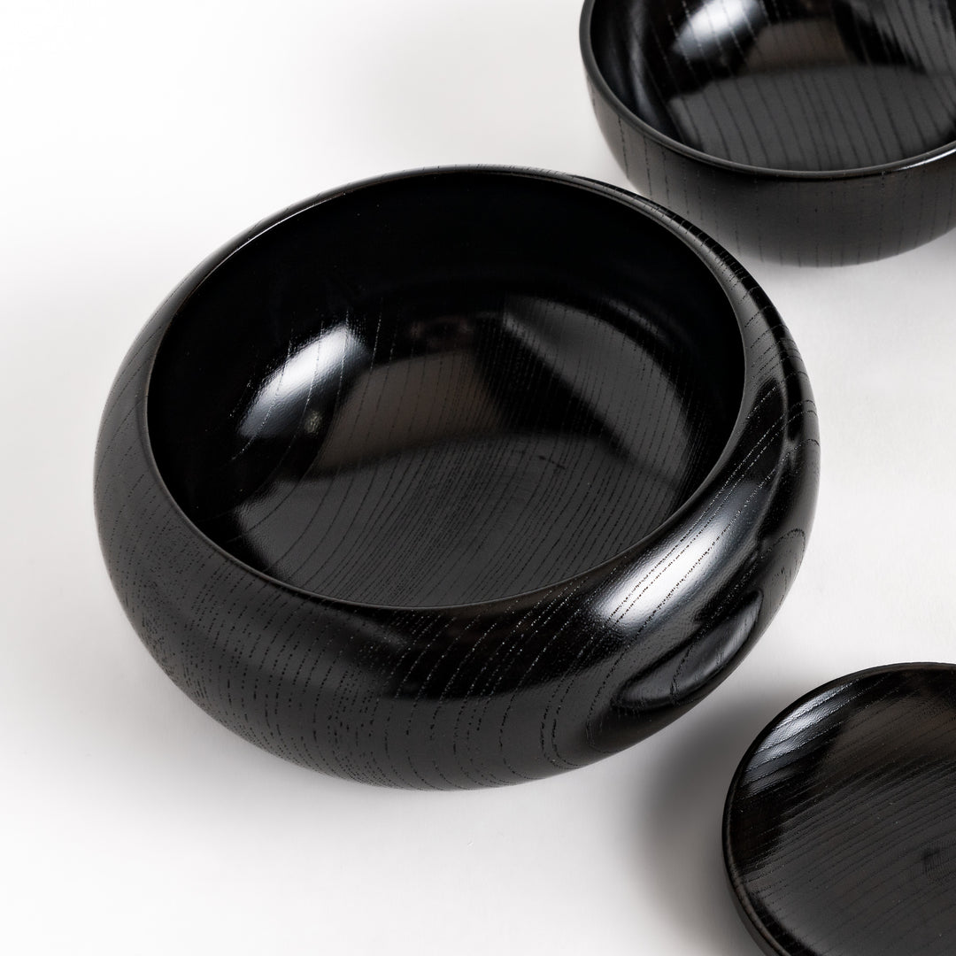 Black lacquered Oryoki bowl set featuring a large serving bowl, three medium bowls, and three small plates with a glossy finish.