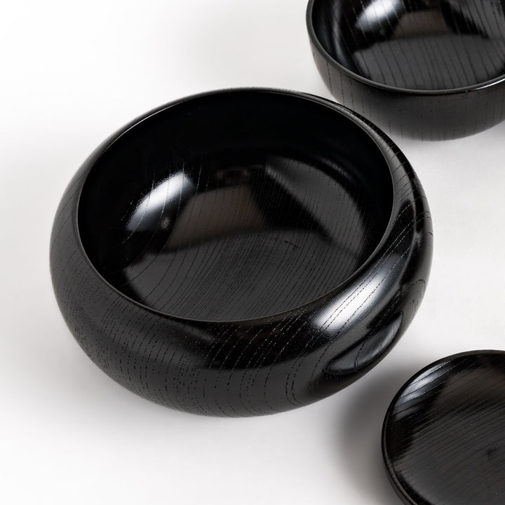 Black lacquered Oryoki bowl set featuring a large serving bowl, three medium bowls, and three small plates with a glossy finish.