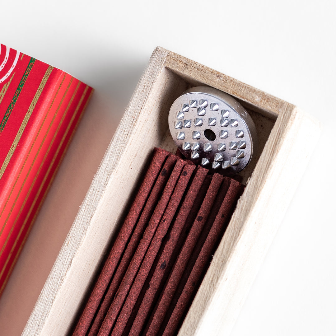 Blissful Apple Incense in a light wooden box with rich red sticks, elegantly packaged in a vibrant red design featuring white circular patterns, evoking a sweet and refreshing apple aroma.