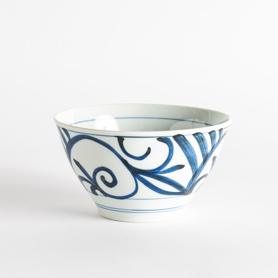 A white ceramic bowl with blue swirling patterns, traditional Japanese design.