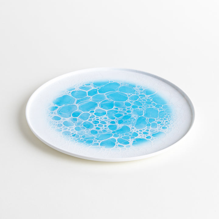 Diagonal angle of the Bubble Dinner Plate, capturing the plate’s elegant form and vibrant blue bubble design.