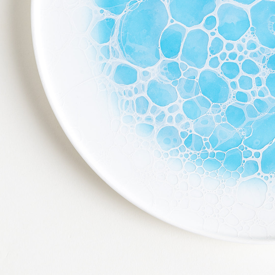 Close-up shot of the Bubble Dinner Plate, focusing on the smooth white surface and blue bubble patterns.