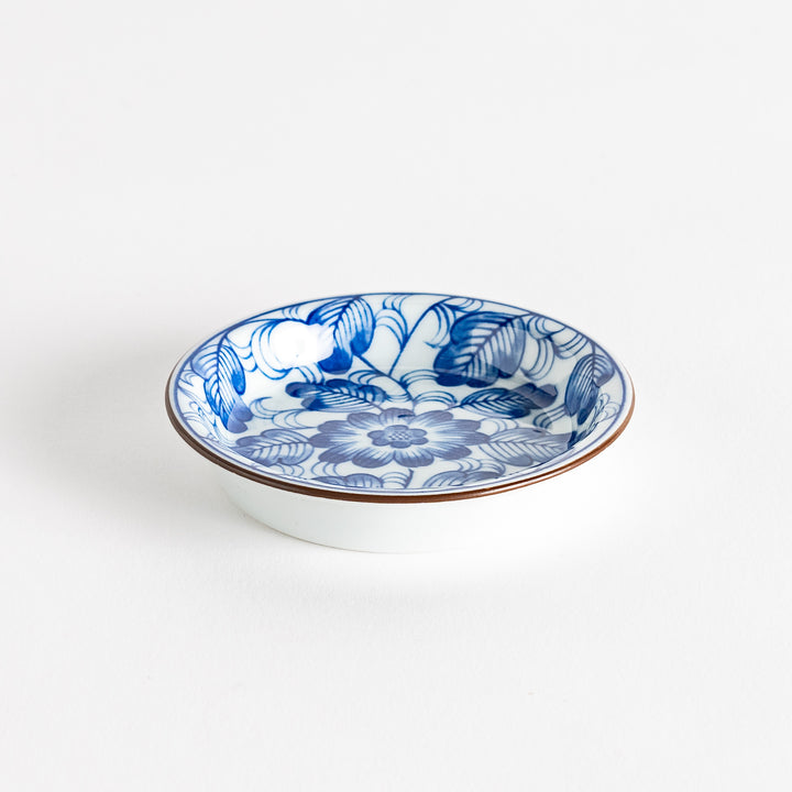 A round saucer featuring a delicate blue floral design on a white background.