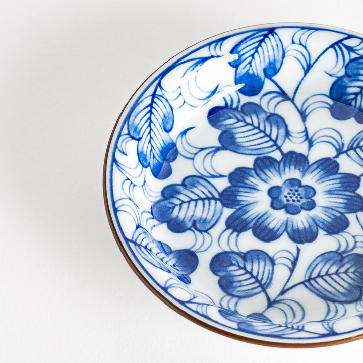 A round saucer featuring a delicate blue floral design on a white background.