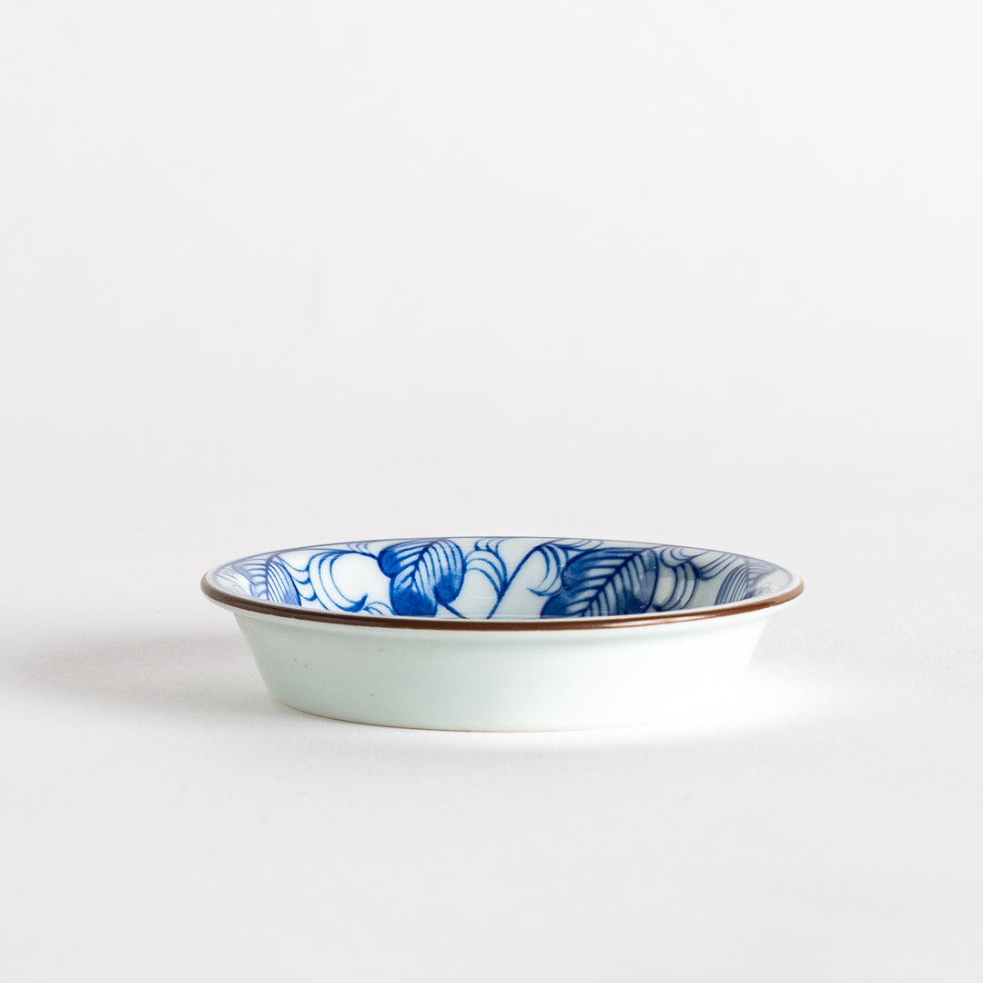 A round saucer featuring a delicate blue floral design on a white background.