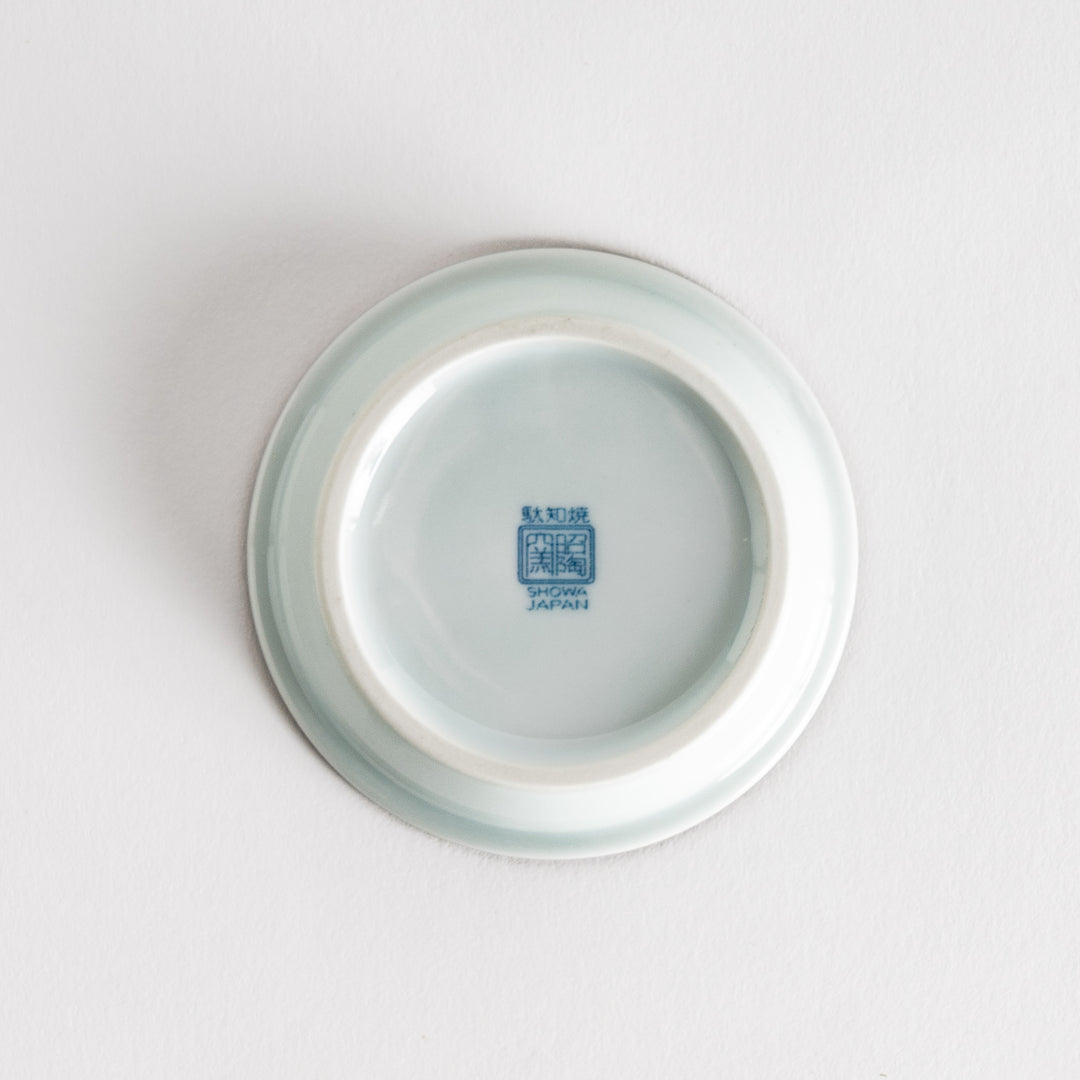 A round saucer featuring a delicate blue floral design on a white background.