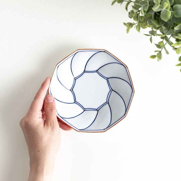 Octagonal dessert plate with a petal design and bowl shape, outlined in blue and red with a brown rim.