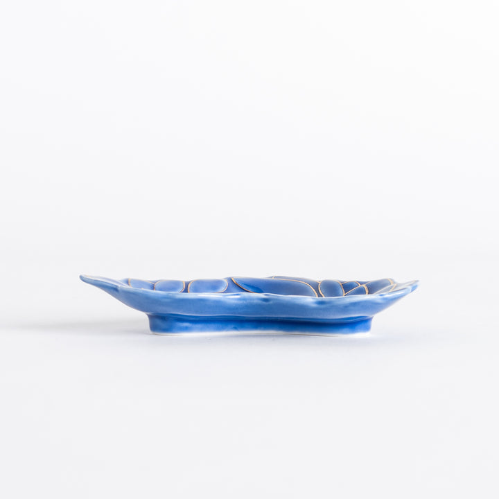 Side view of the blue mini sauce dish with a gold chrysanthemum design. The dish has a shallow, curved shape.