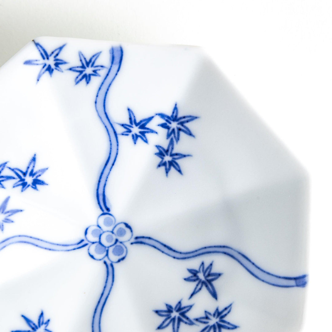 Octagonal white plate with blue floral patterns and curved lines.