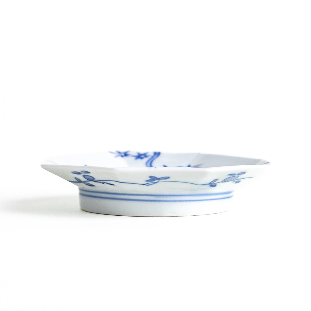 Octagonal white plate with blue floral patterns and curved lines.