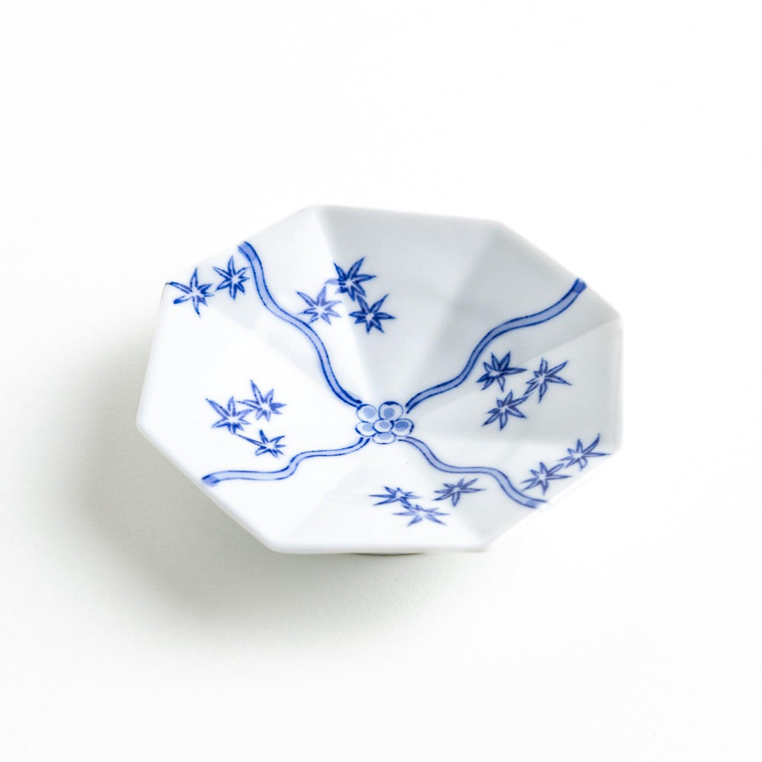 Octagonal white plate with blue floral patterns and curved lines.