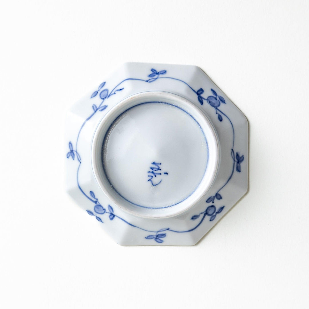 Octagonal white plate with blue floral patterns and curved lines.