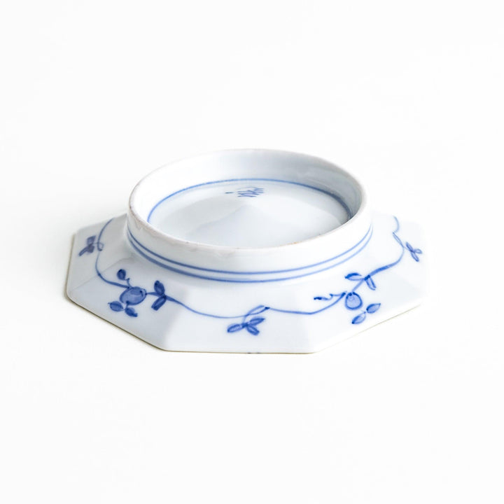 Octagonal white plate with blue floral patterns and curved lines.