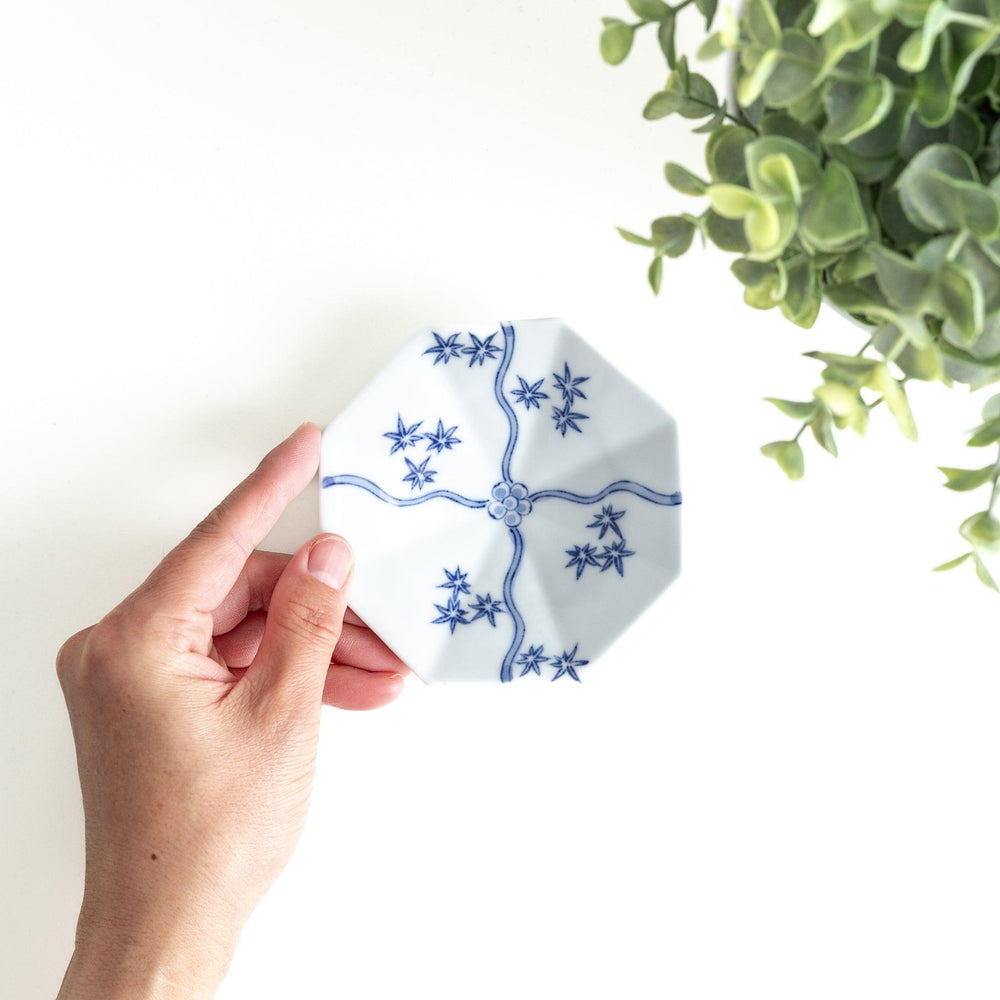 Octagonal white plate with blue floral patterns and curved lines.