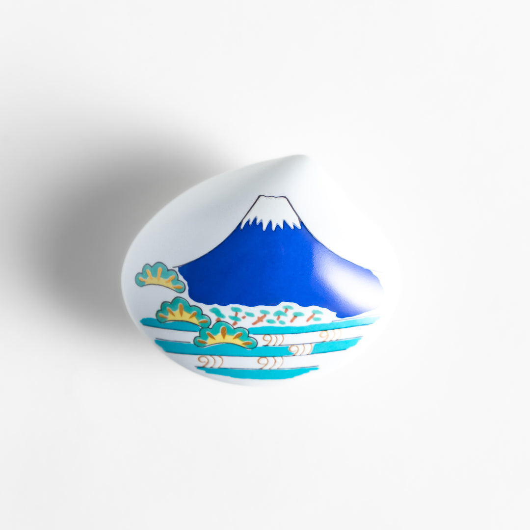 White ceramic incense holder shaped like a seashell, featuring a vivid blue Mount Fuji design with golden accents and a secure incense stand inside for elegant display.