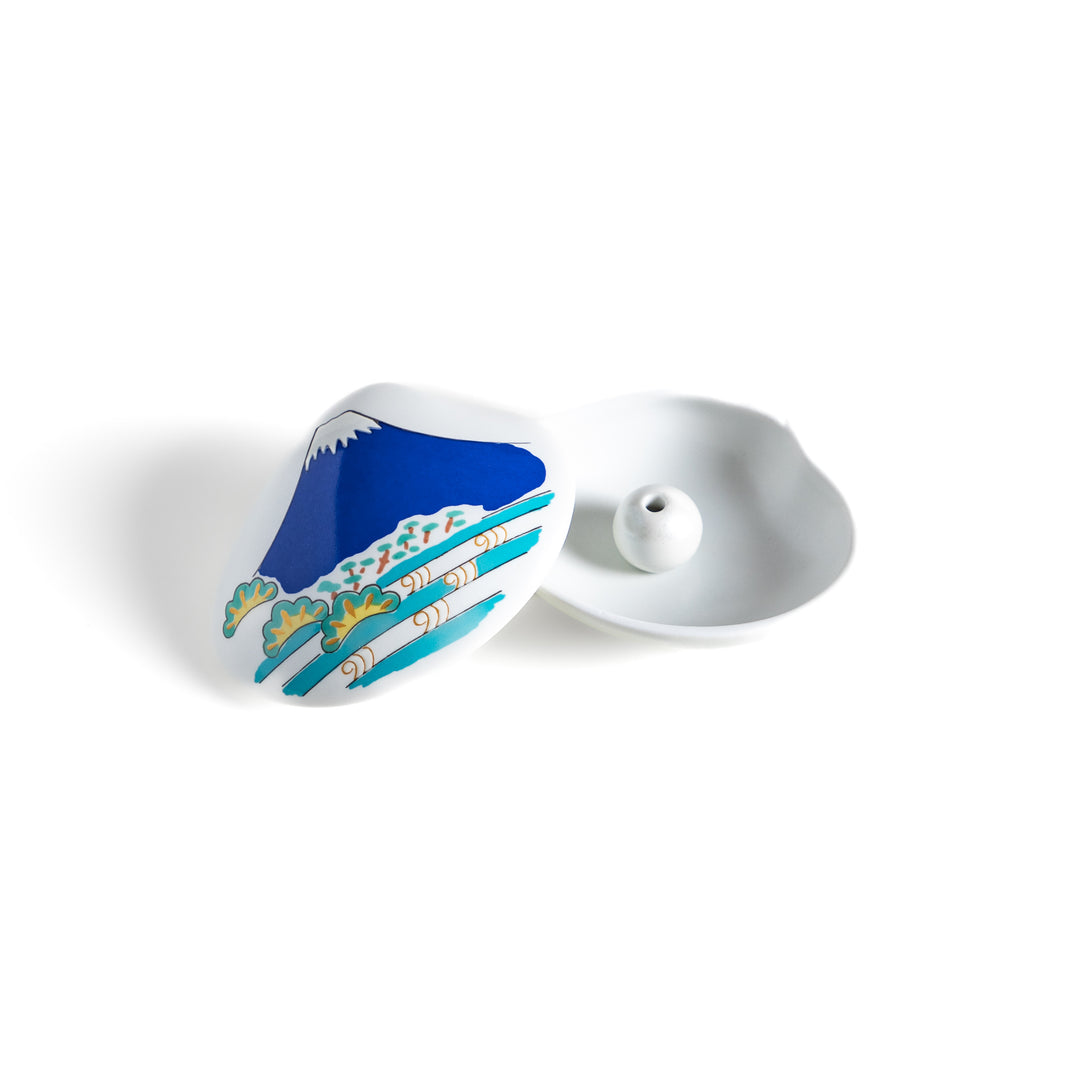 White ceramic incense holder shaped like a seashell, featuring a vivid blue Mount Fuji design with golden accents and a secure incense stand inside for elegant display.