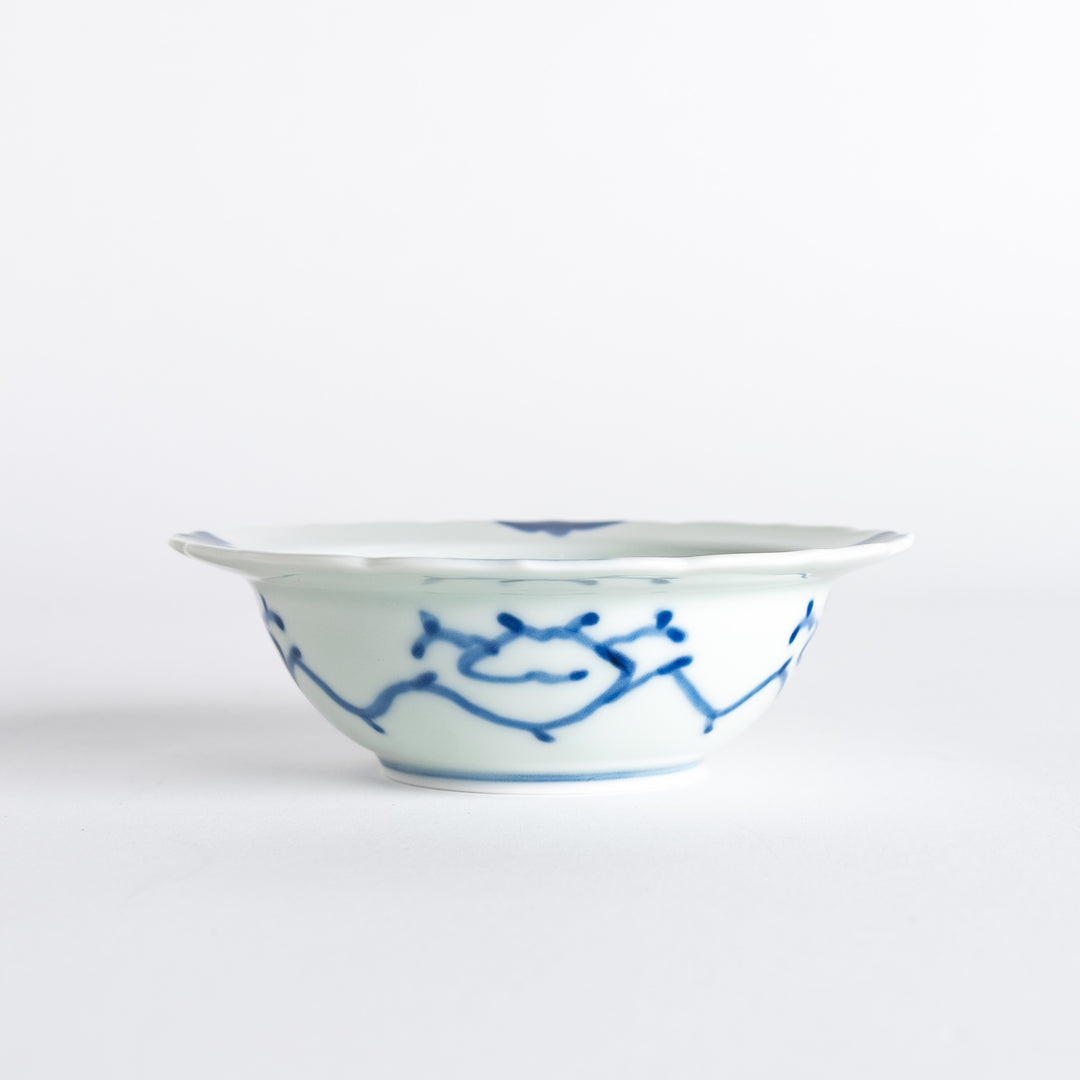 A dessert bowl with blue peony flower motifs at the center and on the rim, framed by soft scalloped edges.