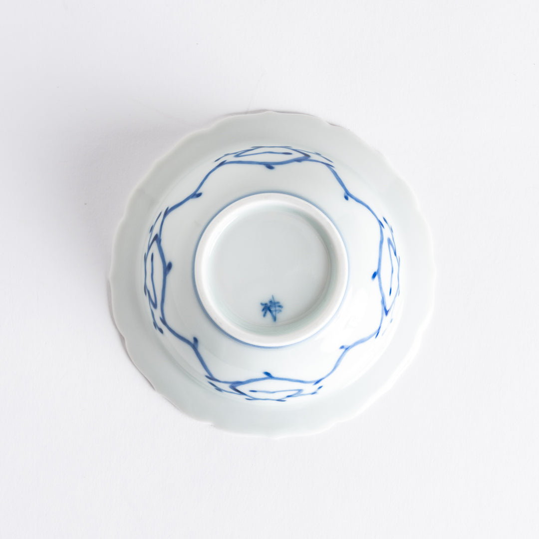 A dessert bowl with blue peony flower motifs at the center and on the rim, framed by soft scalloped edges.