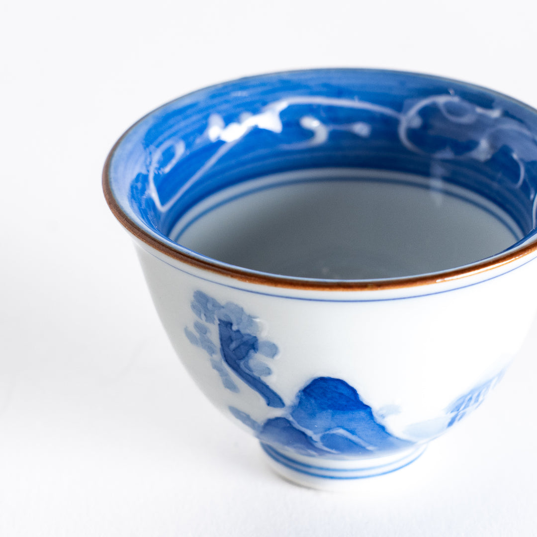 Close-up of the sake cup’s hand-painted blue wave design on the inside and the detailed rim.