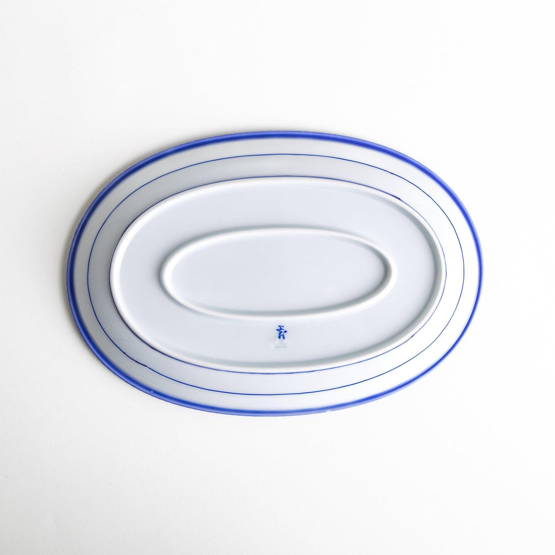 An oval-shaped white dinner plate with a rustic scallop-edged design. The border comes in blue, brown, and olive.